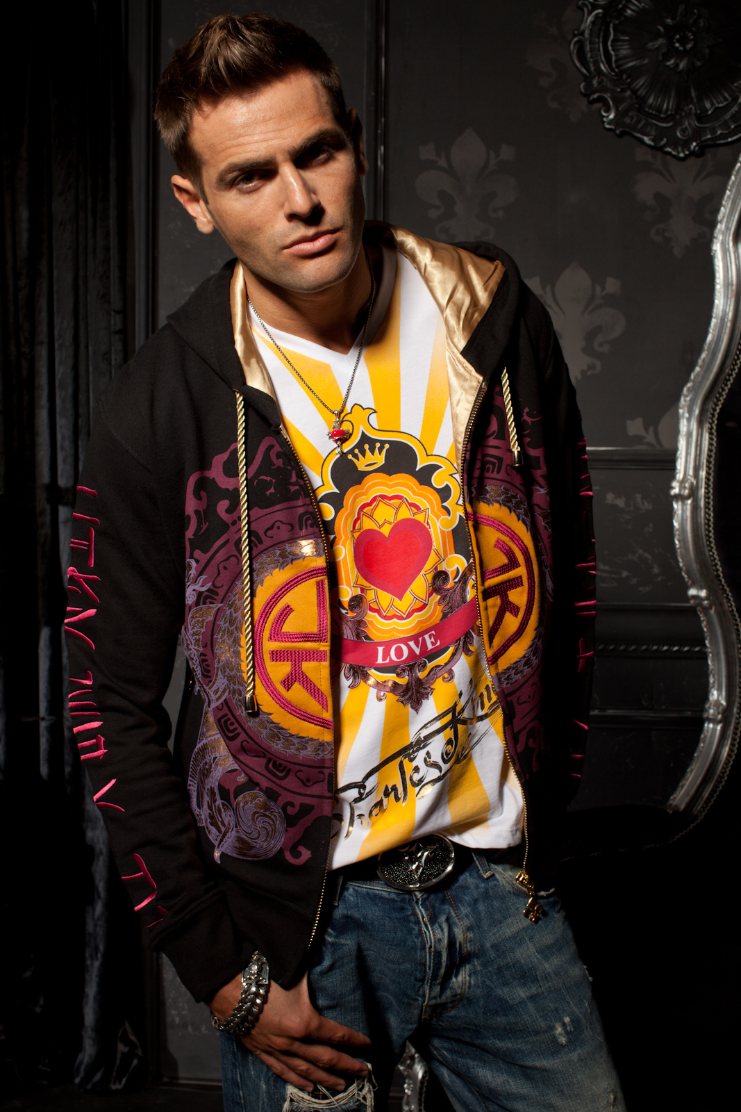 Man wearing a black Charles King Paris hoodie with vivid heart artwork